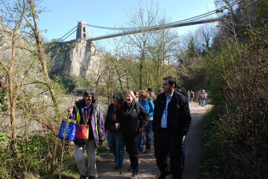 people walking under the clifton suspension bridge